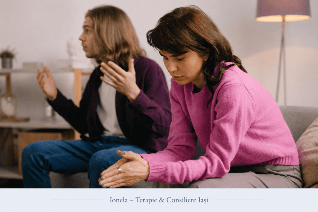 Femeie retrasă emoțional în timpul unei discuții de cuplu, ilustrând mecanismele de apărare și dificultatea de conectare emoțională.